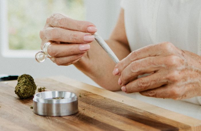 Idoso segurando um baseado de maconha